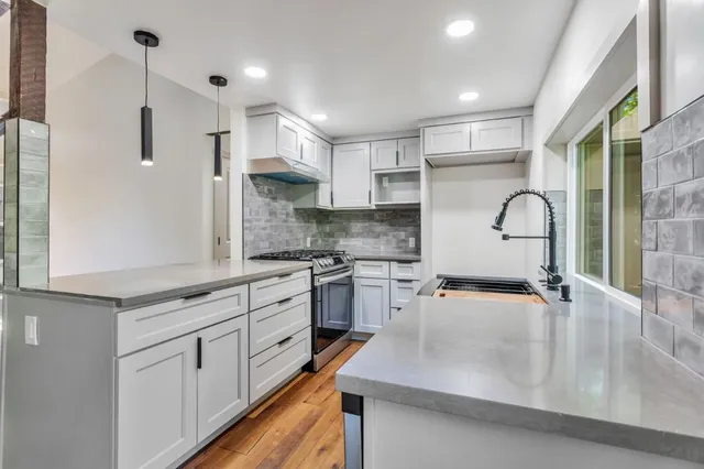 a kitchen with furniture a stove and a window