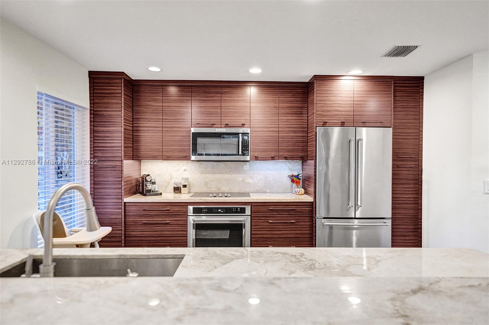 10150 Camelback Lane Boca Raton, FL 33498 - Photo 20 of 67 a kitchen with stainless steel appliances granite countertop a sink and a stove
