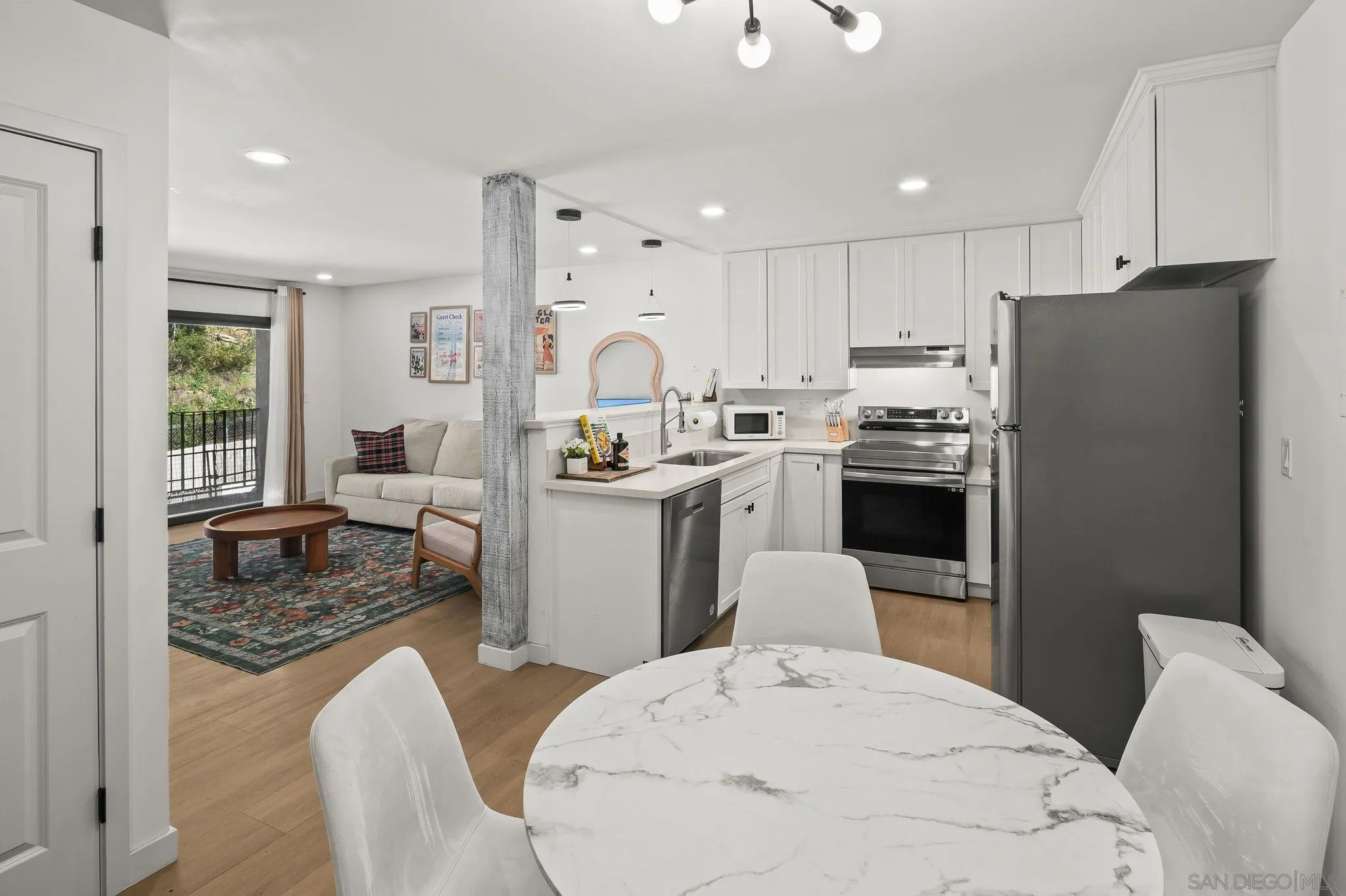 a kitchen with stainless steel appliances kitchen island granite countertop a sink a stove a refrigerator cabinets and chairs