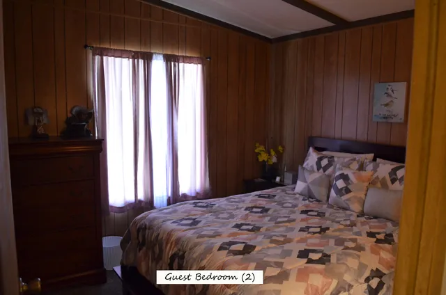 a bed room with a wooden floor and a chair