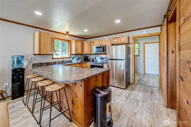 a kitchen with stainless steel appliances granite countertop a refrigerator a sink a stove and island