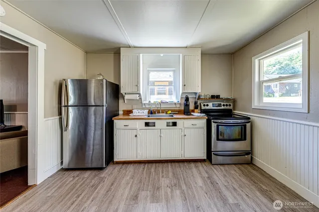 a kitchen with a refrigerator and a stove top oven