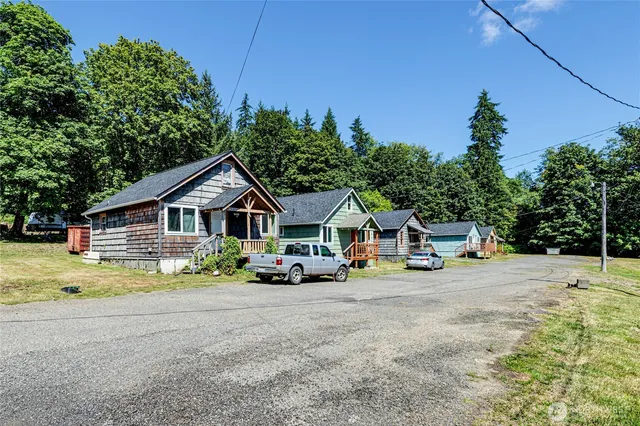 a view of a house with large trees and yard