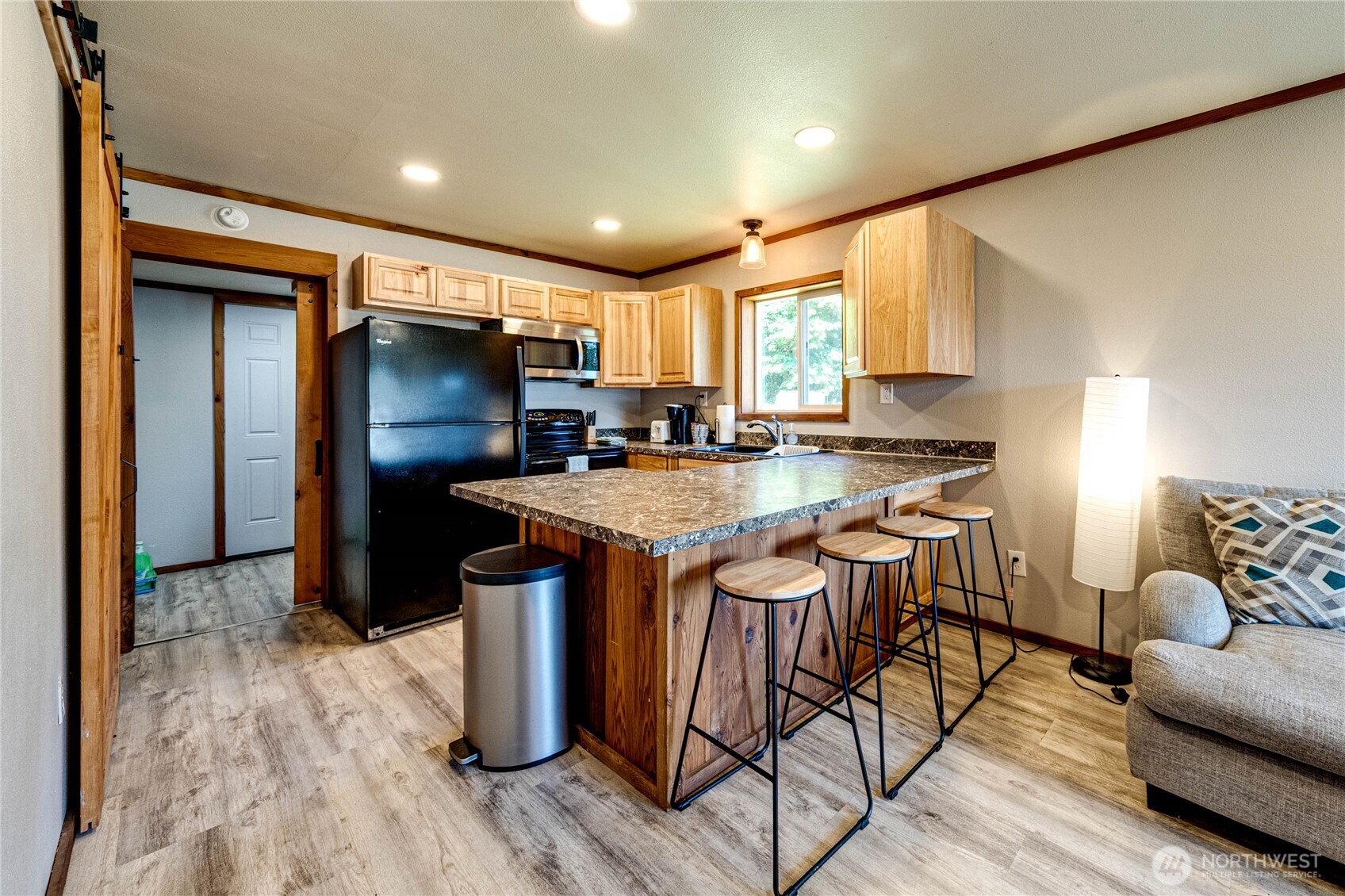 20 Smithville Road Beaver, WA 98305 - Photo 9 of 40 a kitchen with stainless steel appliances granite countertop a refrigerator a sink dishwasher a stove and a dining table with wooden floor