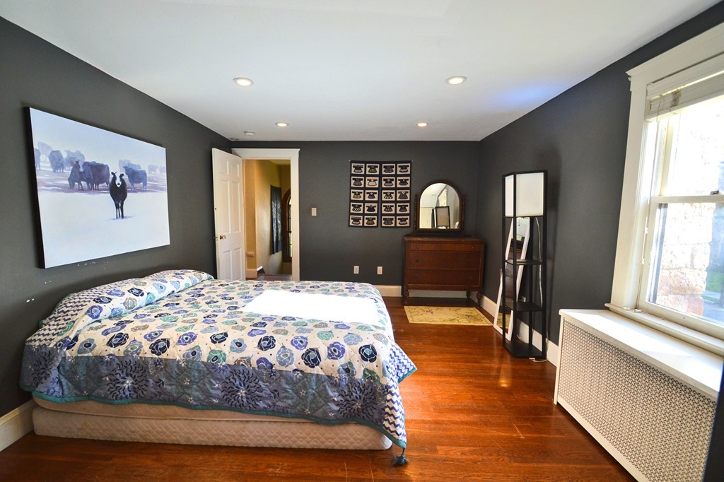 53 Arapahoe Road Newton, MA 02465 - Photo 16 of 25 a bedroom with a large bed and wooden floor