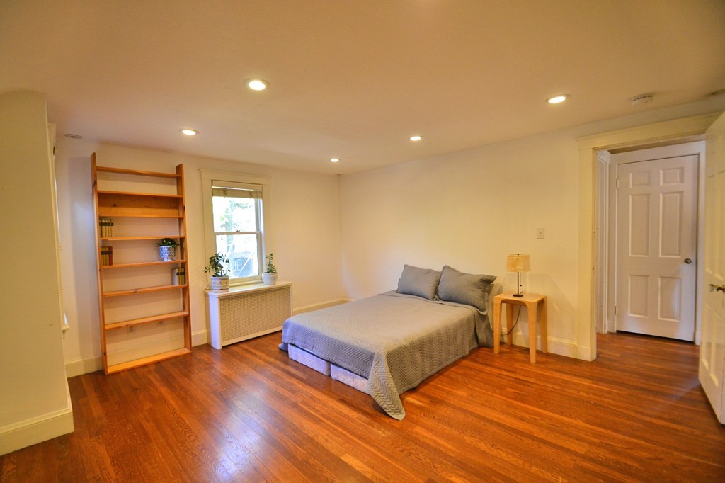 53 Arapahoe Road Newton, MA 02465 - Photo 17 of 25 a bedroom with a bed and wooden floor