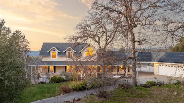 aerial view of a house with a table and chairs under an umbrella
