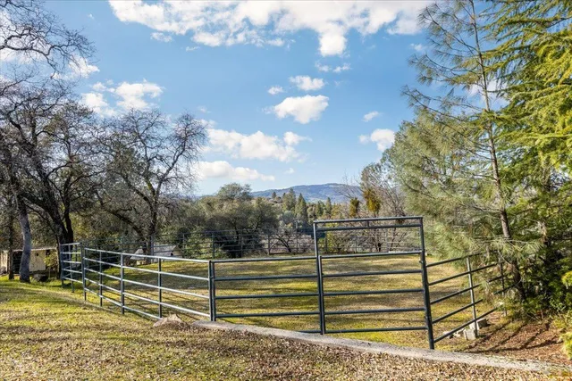 a view of a house with a big yard and large trees