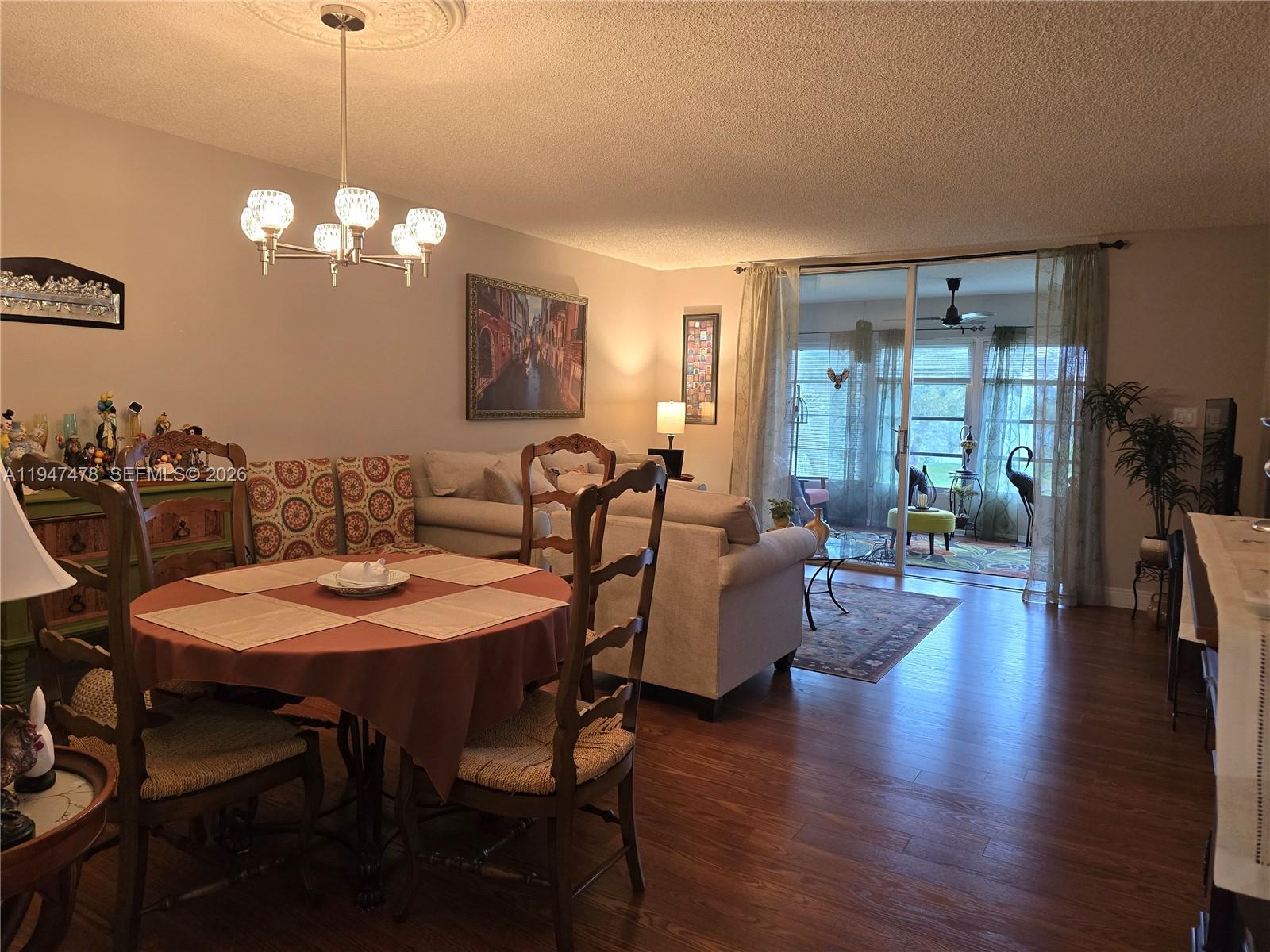 7690 Northwest 18th Street, Unit 306 Margate, FL 33063 - Photo 3 of 30 a view of a dining room with furniture wooden floor and chandelier