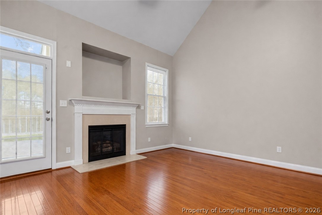 55 London Way Spring Lake, NC 28390 - Photo 18 of 43 an empty room with wooden floor fireplace and windows