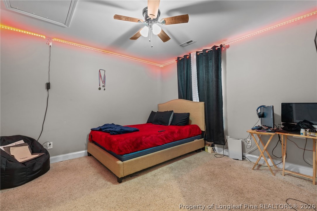55 London Way Spring Lake, NC 28390 - Photo 32 of 43 a spacious bedroom with a bed a couch and a chandelier