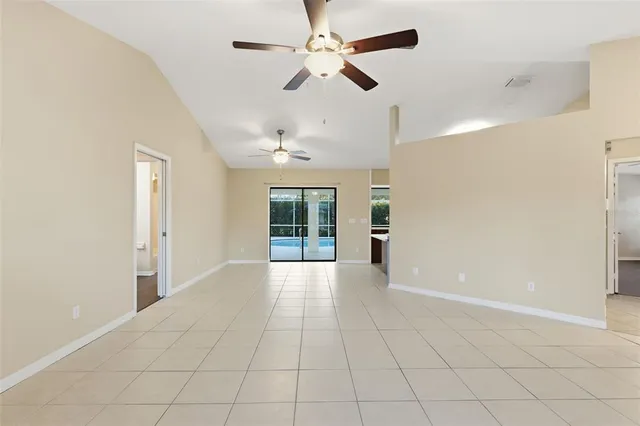 a view of an empty room with a chandelier fan