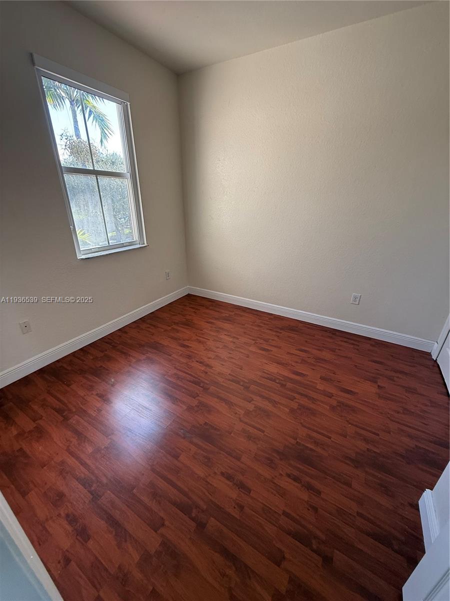 904 Southwest 154th Path Miami, FL 33194 - Photo 13 of 18 an empty room with wooden floor and windows