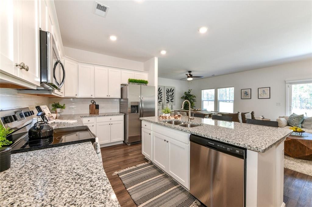 12006 Crosswicks Road, Unit SUNSHINE Union City, GA 30291 - Photo 7 of 20 a kitchen with granite countertop a sink stove and cabinets