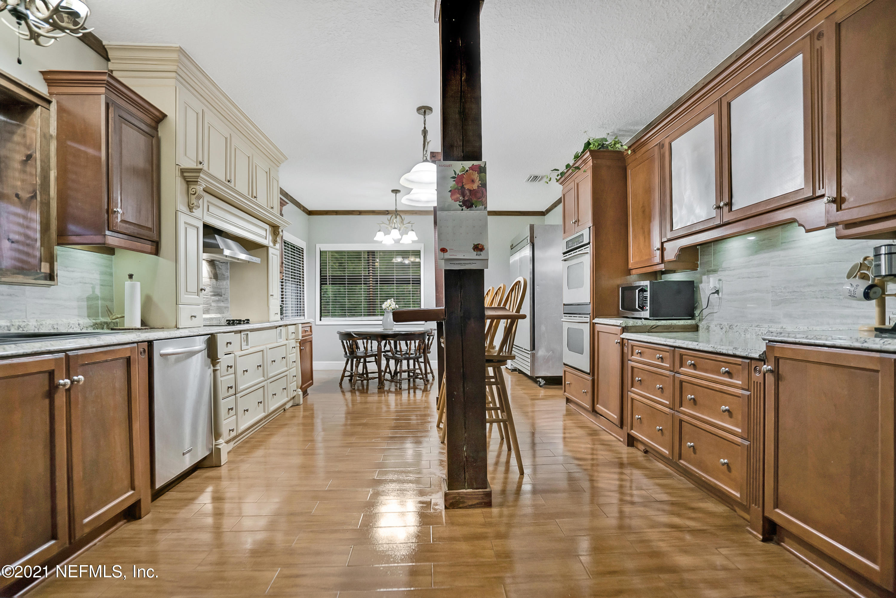 444 George Mosley Road Jacksonville, FL 32234 - Photo 10 of 58 a kitchen with stainless steel appliances granite countertop a stove top oven a sink a dining table and chairs with wooden floor