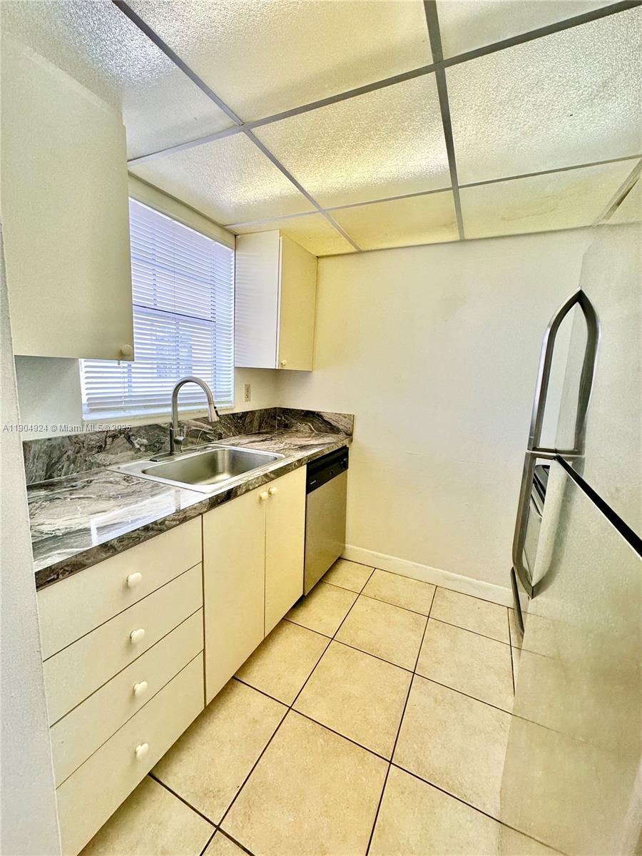 8600 Southwest 109th Avenue, Unit 4211 Miami, FL 33173 - Photo 24 of 25 a kitchen with a sink a stove and cabinets