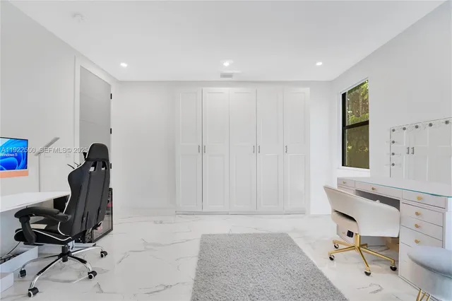 a view of a workspace with furniture and a window