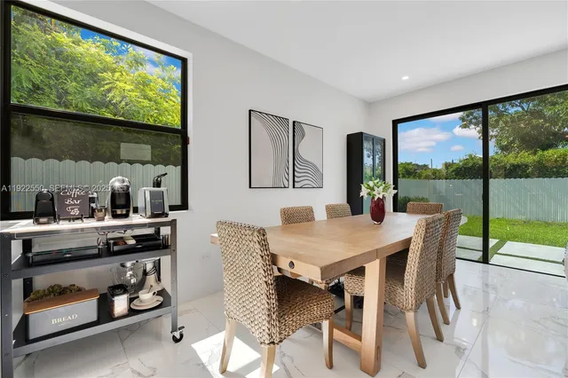 a view of a dining room with furniture large windows and garden view