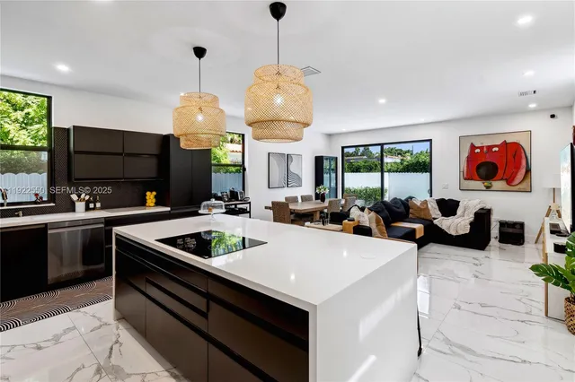a kitchen with stainless steel appliances granite countertop a sink a stove and a wooden floors