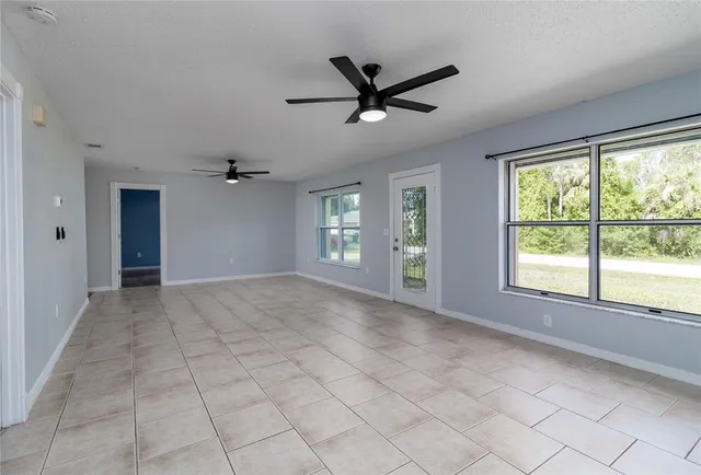 a view of a livingroom with a ceiling fan and window