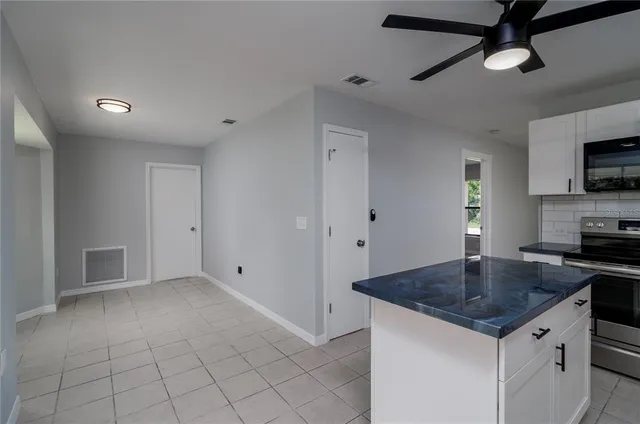 a kitchen with granite countertop a sink a counter top space appliances and cabinets