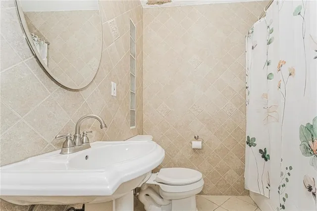 a bathroom with a sink a toilet and a mirror