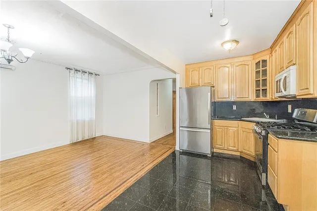 a kitchen with stainless steel appliances granite countertop a refrigerator and a stove top oven