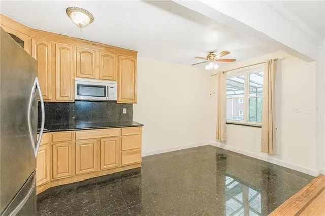 a kitchen with stainless steel appliances granite countertop a stove a sink and a refrigerator with white cabinets