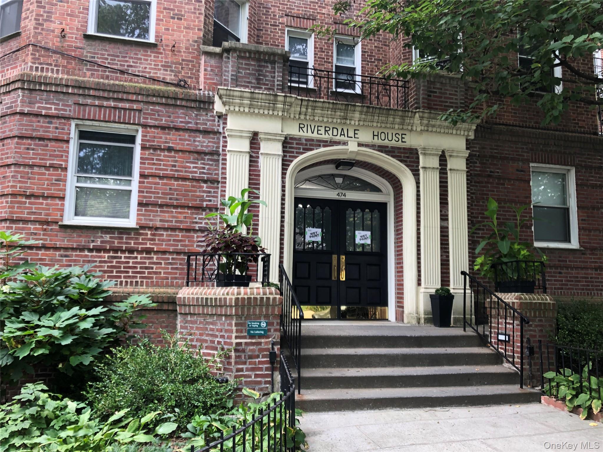 a front view of a house with potted plants