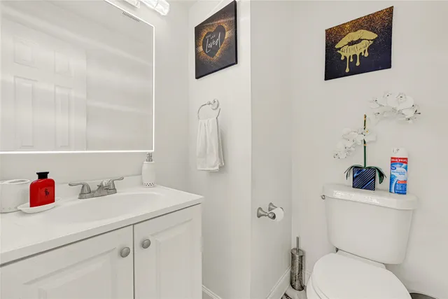 a bathroom with a sink vanity mirror and toilet