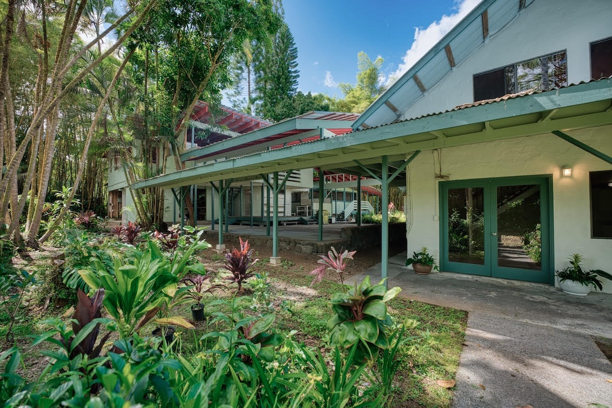 17-406 13 Mile Road Kurtistown, HI 96749 - Photo 11 of 29 a view of a house with potted plants and a table and chairs
