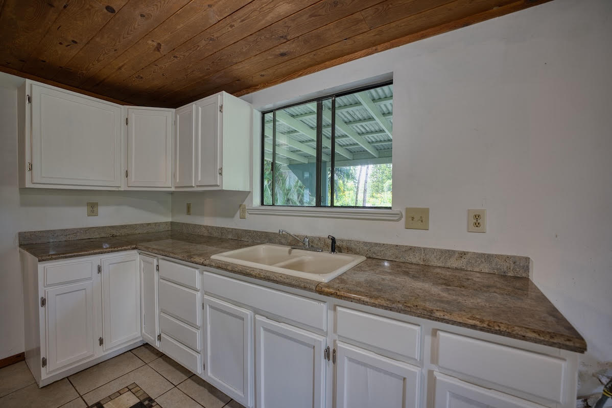 17-406 13 Mile Road Kurtistown, HI 96749 - Photo 16 of 29 a kitchen with granite countertop a sink and dishwasher cabinets
