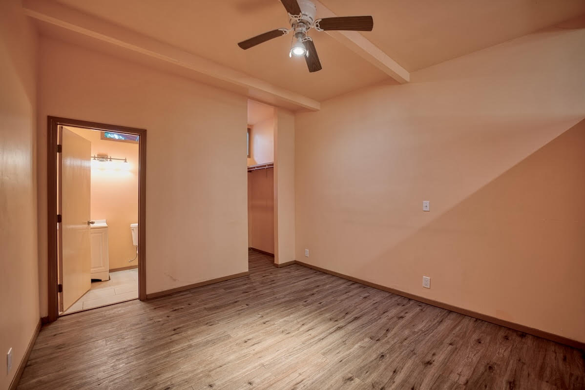 17-406 13 Mile Road Kurtistown, HI 96749 - Photo 21 of 29 a view of an empty room with wooden floor and a ceiling fan