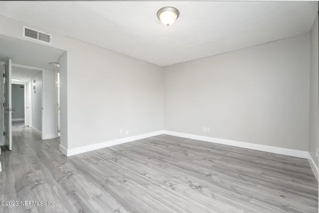 a view of an empty room with wooden floor