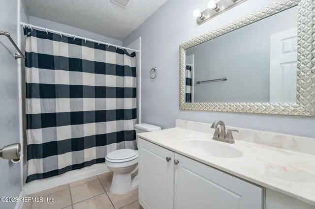 a bathroom with a sink a toilet a mirror and shower