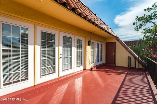 a view of an empty room with wooden floor and fence