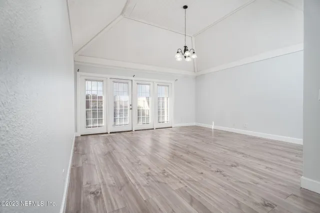 a view of empty room with wooden floor and window