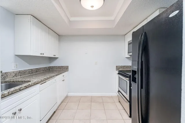 a kitchen with granite countertop a refrigerator and a stove