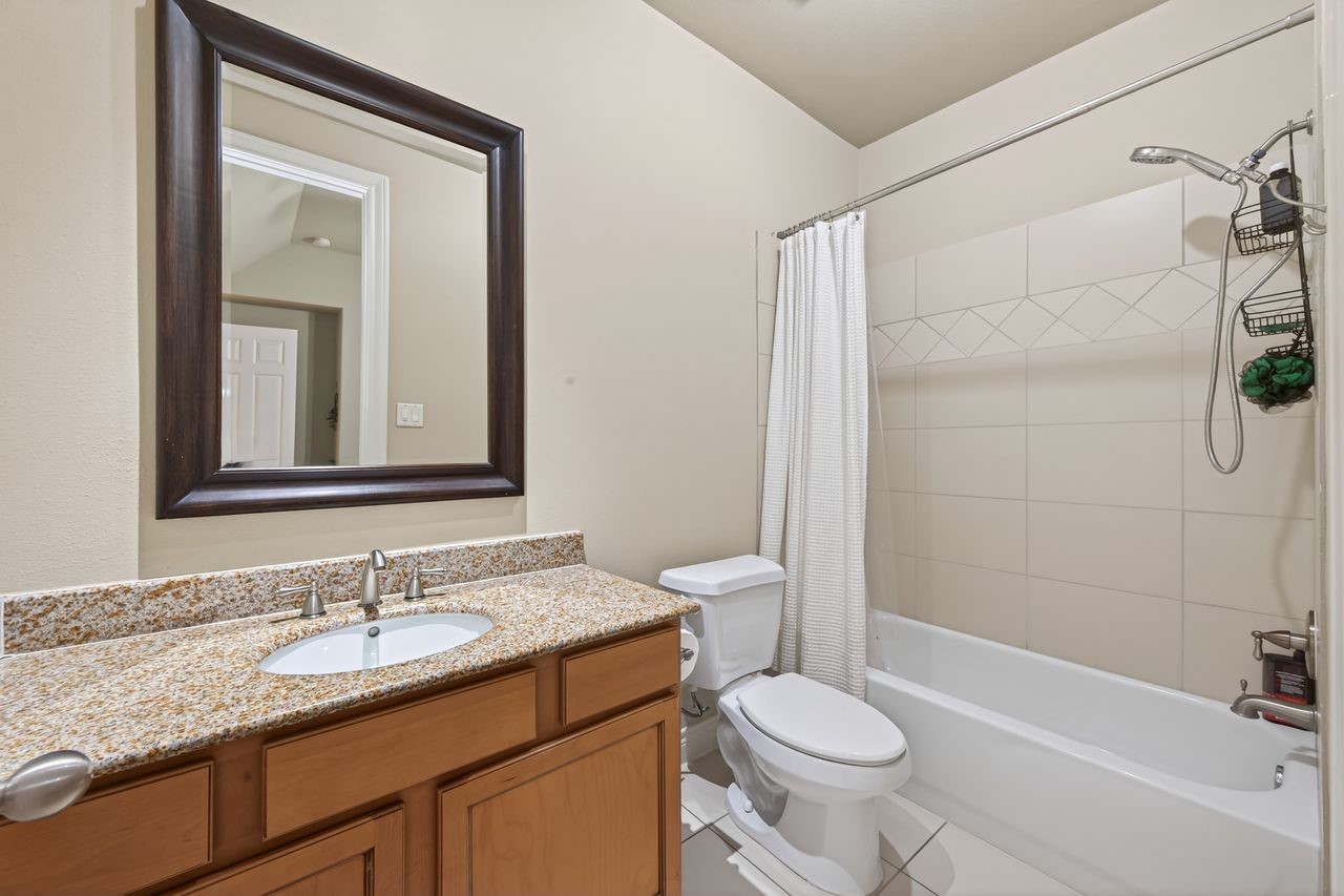 10932 Lasso Lane Houston, TX 77079 - Photo 23 of 38 a bathroom with a granite countertop sink toilet and shower