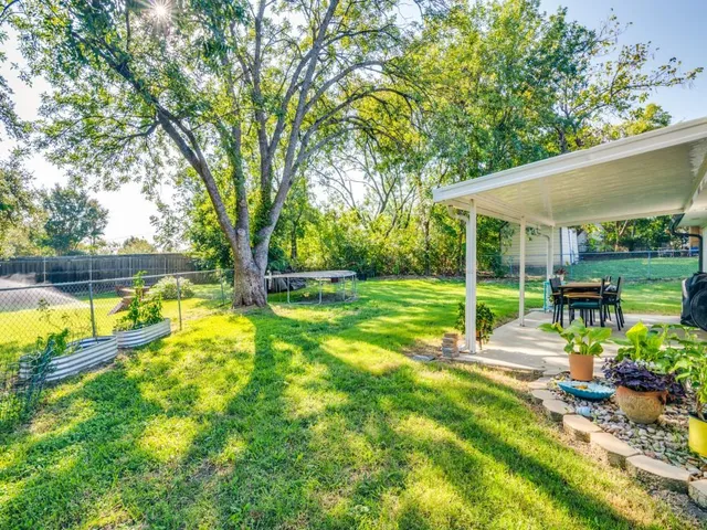 a view of backyard with swimming pool and seating space