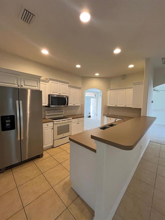 4458 Maverick Street North Port, FL 34288 - Photo 4 of 8 a kitchen with stainless steel appliances granite countertop a sink and a refrigerator