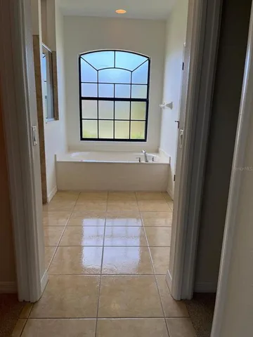 a bathroom with a tub shower and window