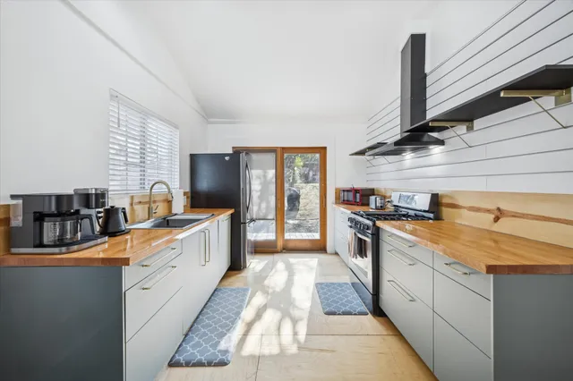 a large kitchen with stainless steel appliances granite countertop a stove a sink and a refrigerator