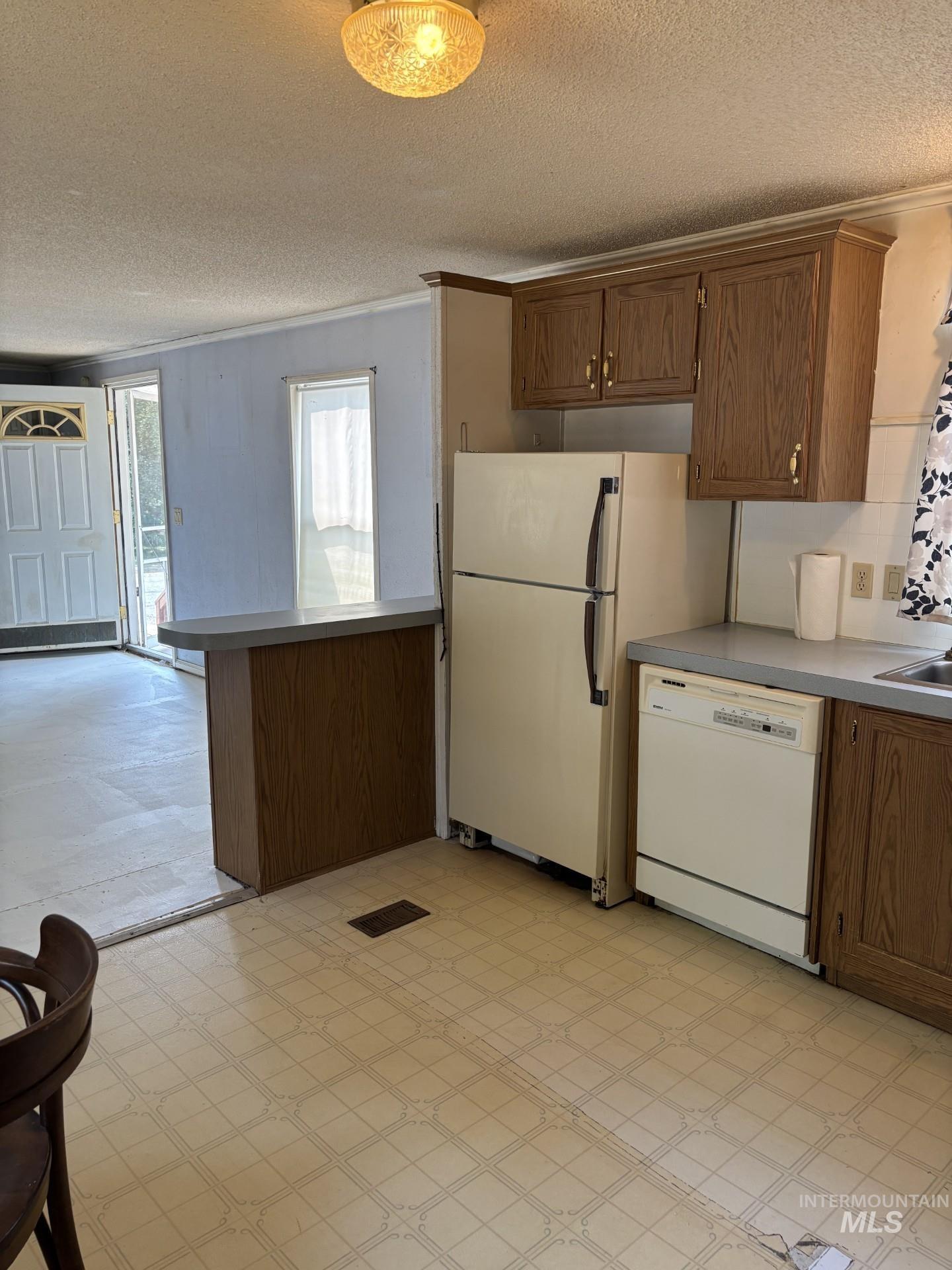 3175 Tomer Road, Unit 25 Moscow, ID 83843 - Photo 9 of 16 Kitchen featuring wood-finish cabinetry, integrated dishwasher, and a refrigerator