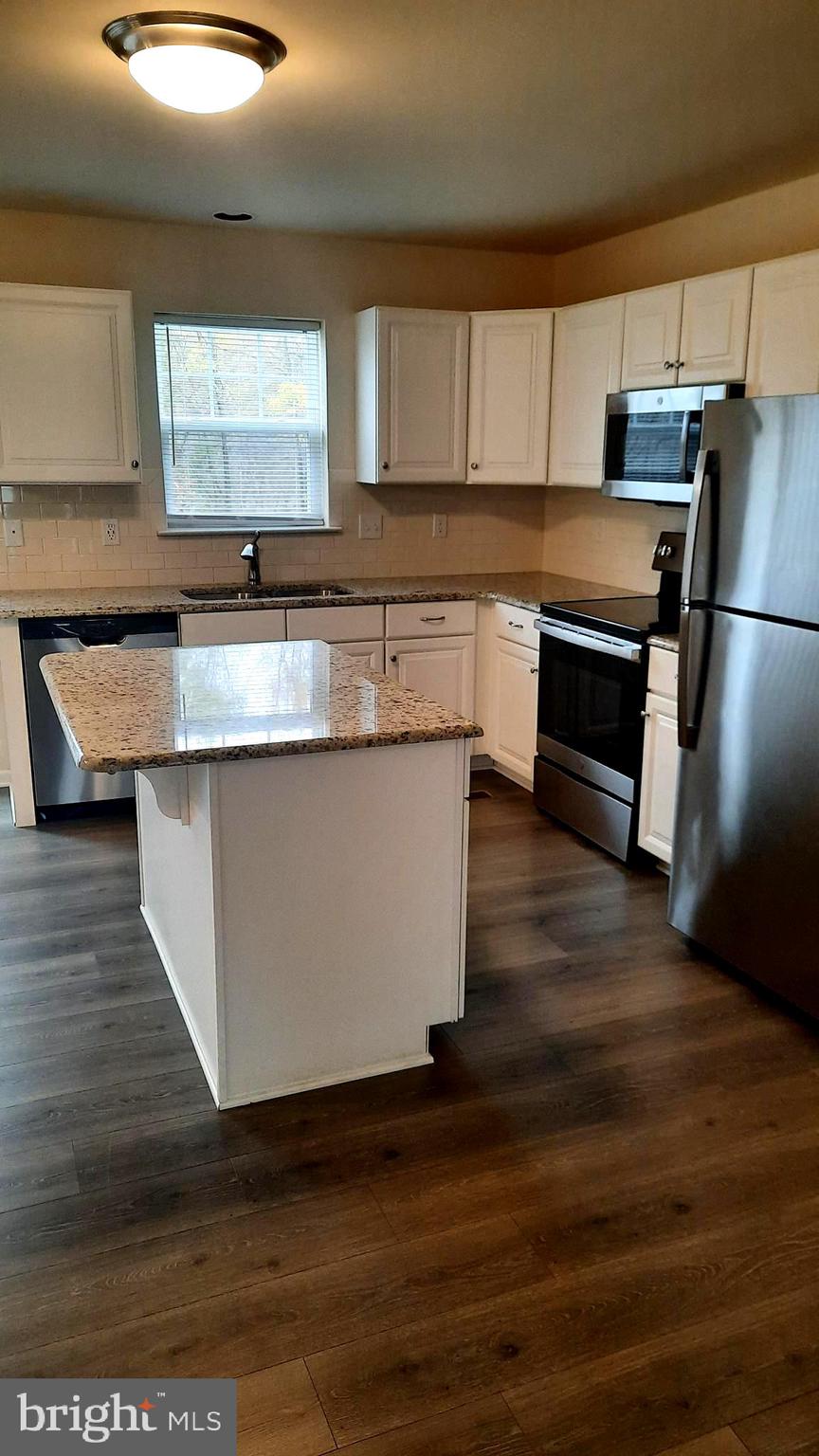 945 Admiral's Quay Drive Mechanicsburg, PA 17050 - Photo 4 of 15 a kitchen with stainless steel appliances granite countertop a stove a sink and a refrigerator
