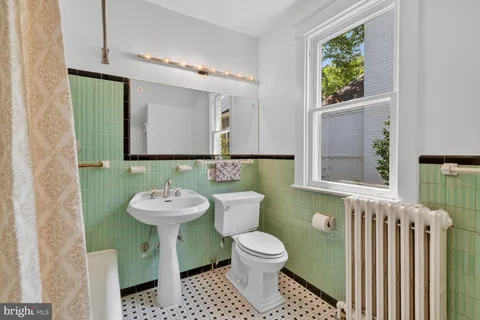 a bathroom with a sink a toilet and mirror