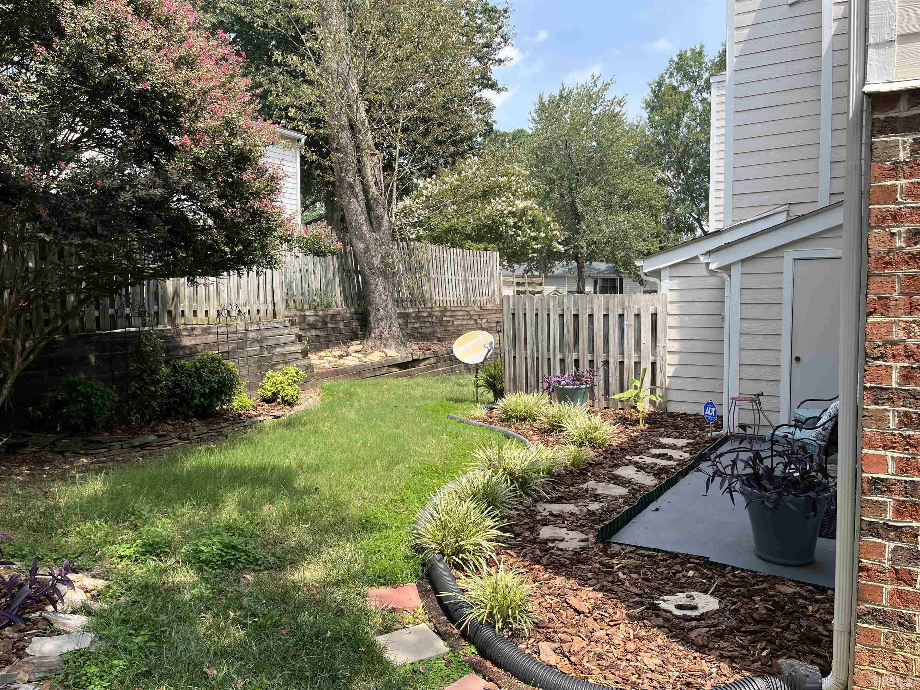 2408 Condor Court, Unit UN2408 Raleigh, NC 27615 - Photo 36 of 39 a view of a backyard with plants and a fence