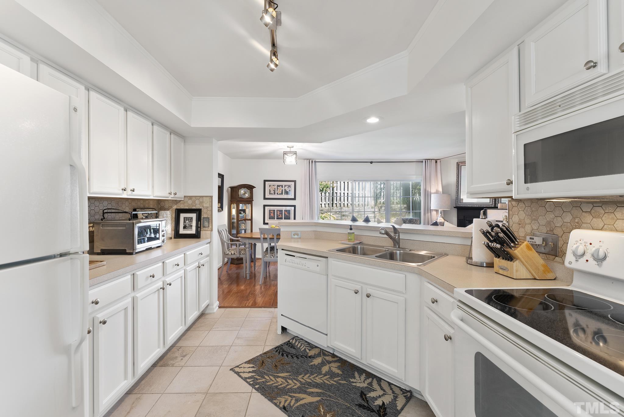 2408 Condor Court, Unit UN2408 Raleigh, NC 27615 - Photo 8 of 39 a kitchen with white cabinets sink and appliances