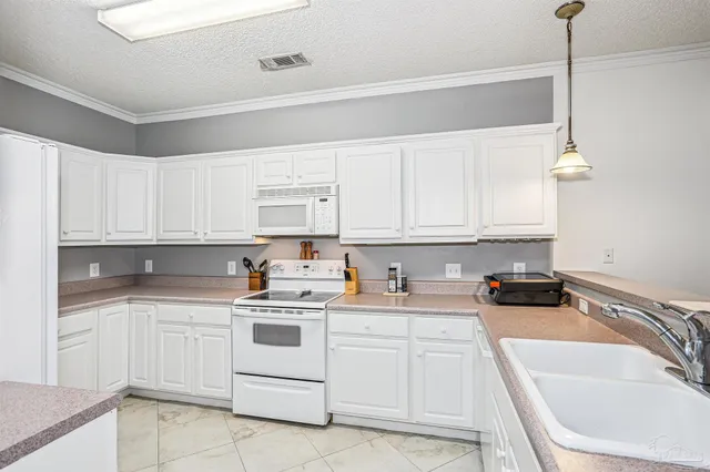 a kitchen with white cabinets sink and white appliances