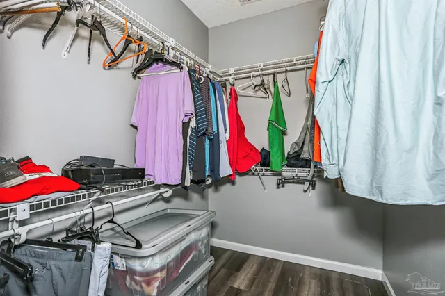 a view of walk in closet with clothes and shoes